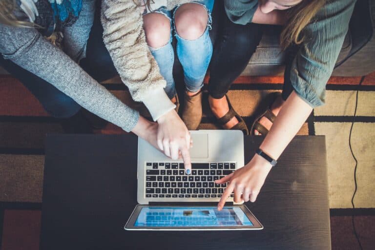 people pointing at a laptop screen