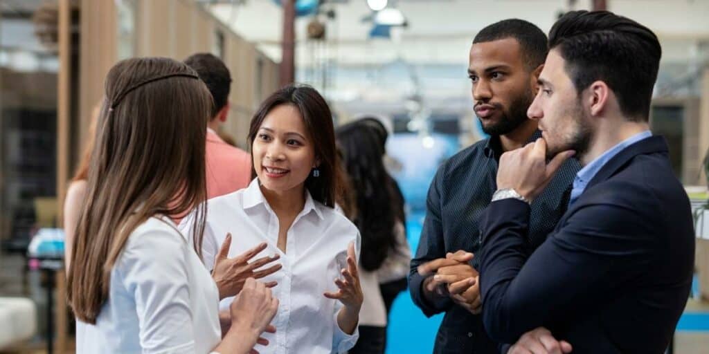 Four people talking at a business trade show